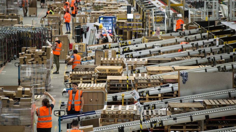 Workers prepare customer orders for dispatch as they work around goods stored inside an Amazon.co.uk fulfillment centre in Peterborough, central England, on November 15, 2017