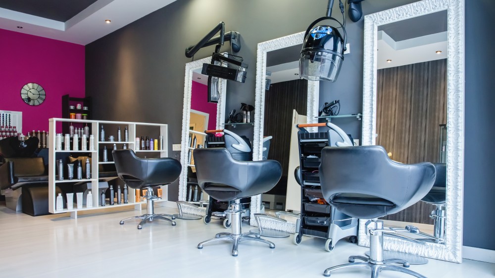 Interior of empty modern hair and beauty salon decorated in gray and fuchsia colors