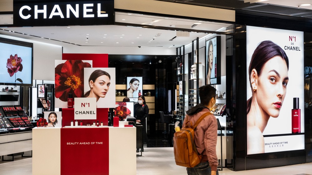 A Chinese shopper walks past a Chanel Beauty store.