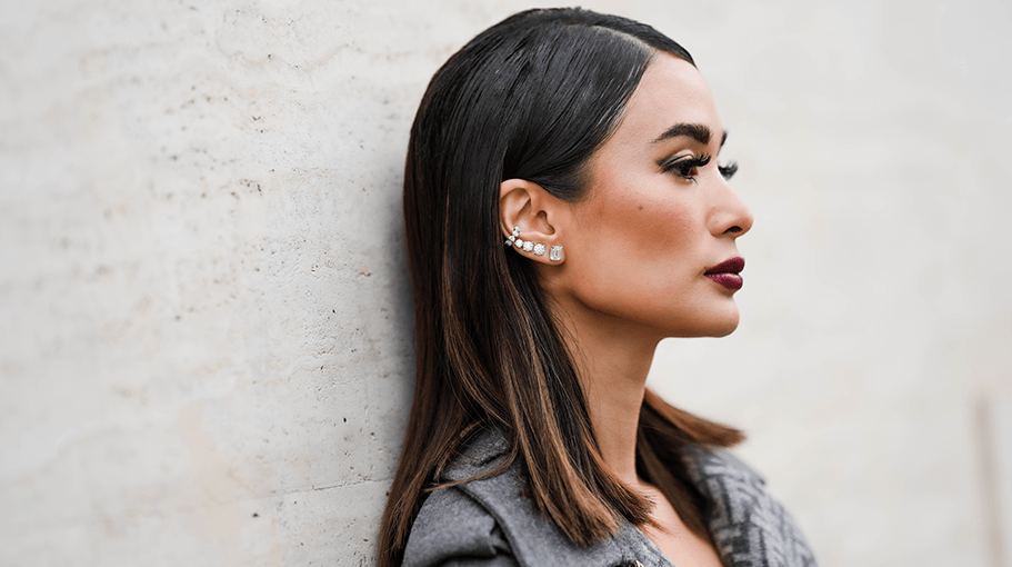 MILAN, ITALY - FEBRUARY 22: Heart Evangelista wears diamonds earrings, a gray with pale gray embossed FF monogram print pattern borders belted long coat from Fendi, outside Fendi, during the Milan Fashion Week Womenswear Fall/Winter 2023/2024 on February 22, 2023 in Milan, Italy.
