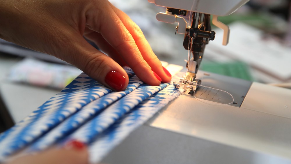 MUNICH, GERMANY - APRIL 30: Airline flight attendant and dirndl designer Birgit Backeler sews protective face masks in her dirndl workshop during the novel coronavirus crisis on April 30, 2020 in Munich, Germany. Backeler normally works as a flight attendant for Lufthansa, a job that has come at least to a temporary halt with the lockdown measures on international travel. And while designing and sewing traditional Bavarian dirndl dresses has long been her second occupational pursuit, Backeler has recently switched to sewing protective face masks, which are currently in high demand across Germany. Backeler chooses designs for the masks from the same fabrics she uses for making dirndls, and also accommodates requests from past dirndl customers for matching masks. Germany this week launched  a nationwide requirement that people must wear masks in shops and while riding public transport. (Photo by Alexander Hassenstein/Getty Images)