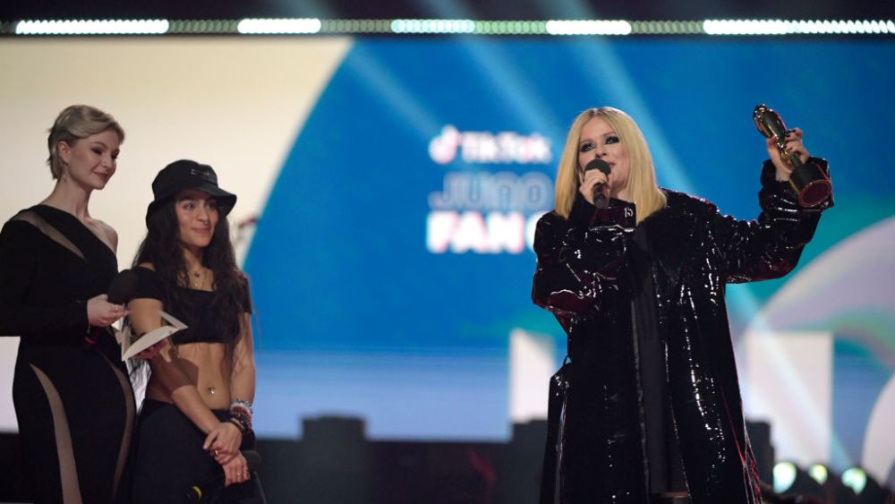 EDMONTON, AB - MARCH 13: (L-R) Kris Collins and Jessie Reyez look on as TIKTOK Juno Fan Choice winner Avril Lavigne speaks at the 2023 JUNO Awards at Rogers Place on March 13, 2023 in Edmonton, Canada. (Photo by Dale MacMillan/Getty Images)