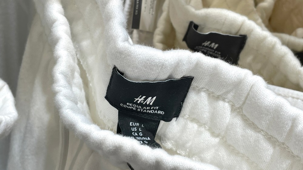 HAYWARD, CALIFORNIA - JUNE 29: Labels are visible on clothing hanging on a rack in an H&M store at Southland Mall on June 29, 2022 in Hayward, California. Swedish fashion retailer H&M reported a 17 percent jump in second quarter earnings with sales totals of $5.37 billion. (Photo by Justin Sullivan/Getty Images)