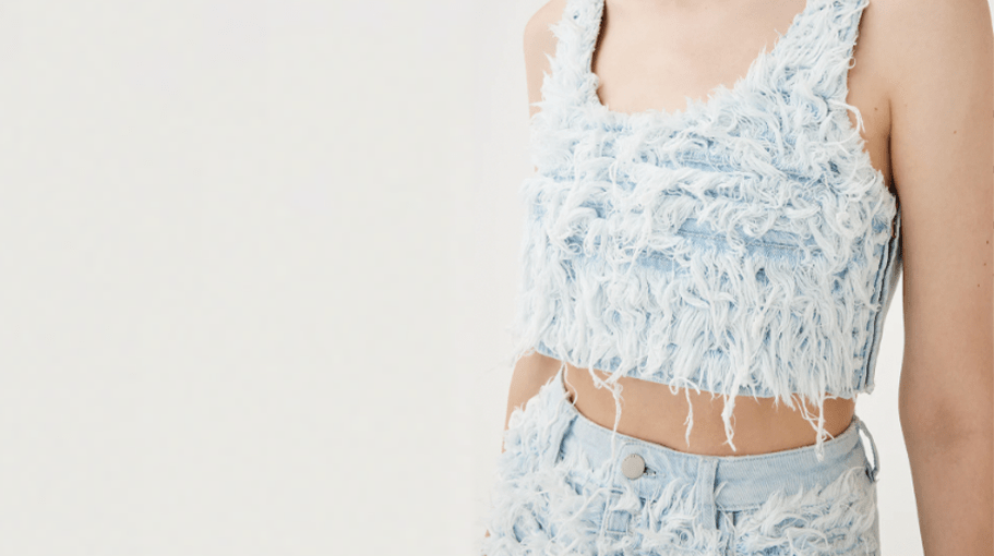 woman wearing a textured denim cropped tank and high waisted jeans