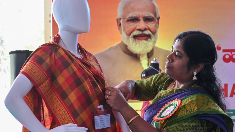 A volunteer drapes a saree on a mannequin during the annual Harshakala National Handloom Fair 2023, an exhibition held to promote the traditional handloom textile practice, in Bengaluru on January 25, 2023.