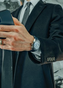 Tag Heuer’s Carrera chronograph CBS2212.FC6535, 39-mm diameter and steel polished case with blue circular brushed dial. Brooks Brothers coat; Emporio Armani blazer, shirt and tie.