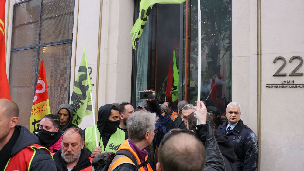 Demonstrators, including French General Confederation of Labour (CGT) and Sud trade unionists, leave the Louis Vuitton store after they occupied the fashion store on the Montaigne avenue in Paris on April 13, 2023, during a demonstration on the 12th day of action after the government pushed a pensions reform through parliament without a vote, using the article 49.3 of the constitution. - France faced nationwide protests and strikes on April 13, 2023, to denounce the French government's pension reform on the eve of a ruling from France's Constutional Council on the reform. (Photo by Thomas SAMSON / AFP) (Photo by THOMAS SAMSON/AFP via Getty Images)