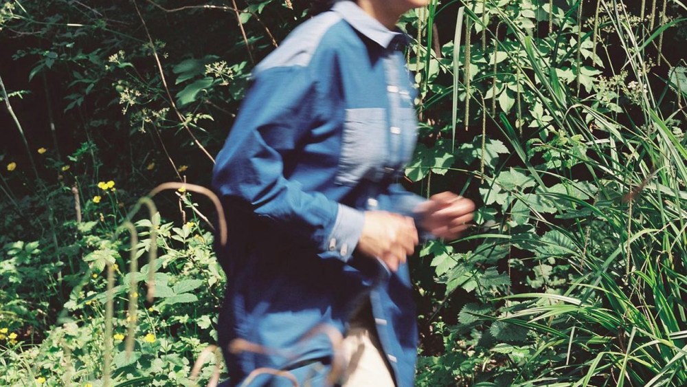 London-based slow fashion label Saywood Studio debuts its denim utility shirt and pant on a model running happily through the brush.