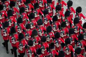 TOPSHOT - Coldstream Guards march along the route of the 'King's Procession', a two kilometres stretch from Buckingham Palace to Westminster Abbey, in central London, on May 6, 2023 ahead of the Coronation of King Charles III. - The set-piece coronation is the first in Britain in 70 years, and only the second in history to be televised. Charles will be the 40th reigning monarch to be crowned at the central London church since King William I in 1066. Outside the UK, he is also king of 14 other Commonwealth countries, including Australia, Canada and New Zealand. Camilla, his second wife, will be crowned queen alongside him and be known as Queen Camilla after the ceremony. (Photo by Carl Court / POOL / AFP) (Photo by CARL COURT/POOL/AFP via Getty Images)