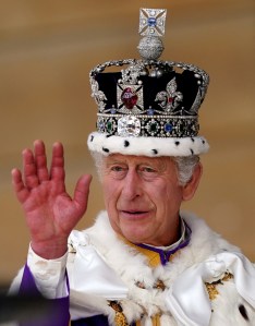 King Charles III waves as he receives a royal salute from members of the military in the gardens of Buckingham Place in London, on May 6, 2023, following his coronation. - The set-piece coronation is the first in Britain in 70 years, and only the second in history to be televised. Charles will be the 40th reigning monarch to be crowned at the central London church since King William I in 1066. Outside the UK, he is also king of 14 other Commonwealth countries, including Australia, Canada and New Zealand. Camilla, his second wife, will be crowned queen alongside him, and be known as Queen Camilla after the ceremony. (Photo by Andrew Milligan / POOL / AFP) (Photo by ANDREW MILLIGAN/POOL/AFP via Getty Images)