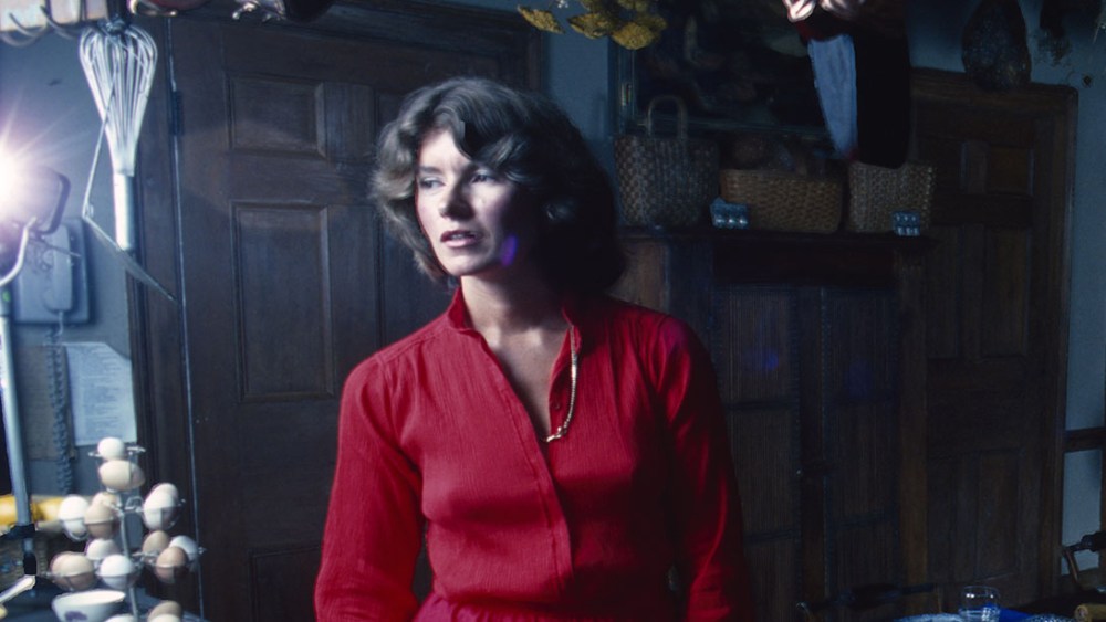 American media mogul and businesswoman, model Martha Stewart young, in a red dress, stands in a kitchen, August 1976. Behind her is a table set with plates, wine, glasses, and a centerpiece while on the counter in front of her is a serving tray of tomato appetizers. (Photo by Susan Wood/Getty Images)