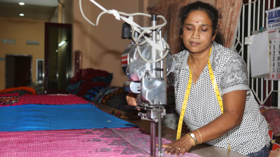 Woman uses a machine to cut fabric at a garment factory in Vavuniya, Sri Lanka.