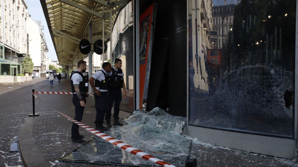 Police officers look at a damaged window of a store at 'Forum des Halles' in Paris on June 30, 2023, after protests following the shooting of a teenage driver by French police in the Paris suburb of Nanterre on June 27. French President Emmanuel Macron was scheduled to chair a new crisis meeting of ministers after a third straight night of nationwide protests over the deadly police shooting of a teenager saw cars torched, shops ransacked and hundreds arrested. (Photo by AFP) (Photo by -/AFP via Getty Images)