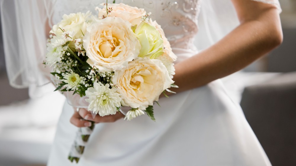 A picture of a bride wearing a white dress, wedding dress trends 2023