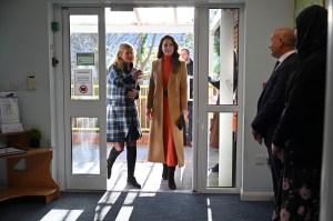 Kate wore a tan coat by Massimo Dutti over a two-piece turtleneck and skirt set from Gabriela Hearst, accessorized with Giavito Rossi boots and Kiki McDonough earrings to Foxcubs Nursery.