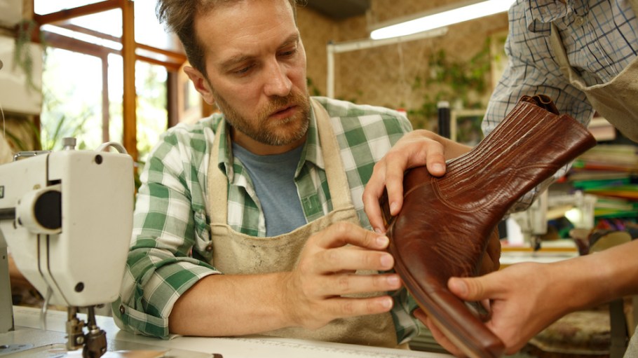 Man inspecting leather boot shoe