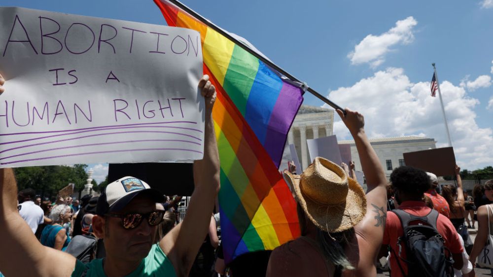 WASHINGTON, DC - JUNE 25: A protester holds a Pride Flag during a protest in the wake of the decision overturning Roe v. Wade  outside the U.S. Supreme Court on June 25, 2022 in Washington, DC. The Supreme Court's decision in Dobbs v Jackson Women's Health overturned the landmark 50-year-old Roe v Wade case and erased a federal right to an abortion. (Photo by Anna Moneymaker/Getty Images)