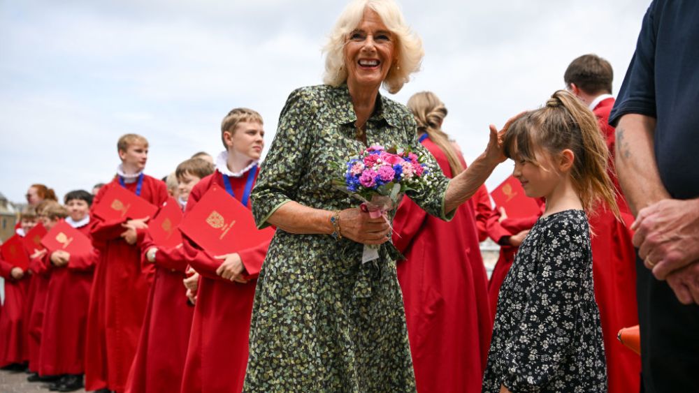 Queen Camilla is given flowers by Williow, outside the RNLI station during an official visit to Cornwall on July 13, 2023 in St Ives, England.
