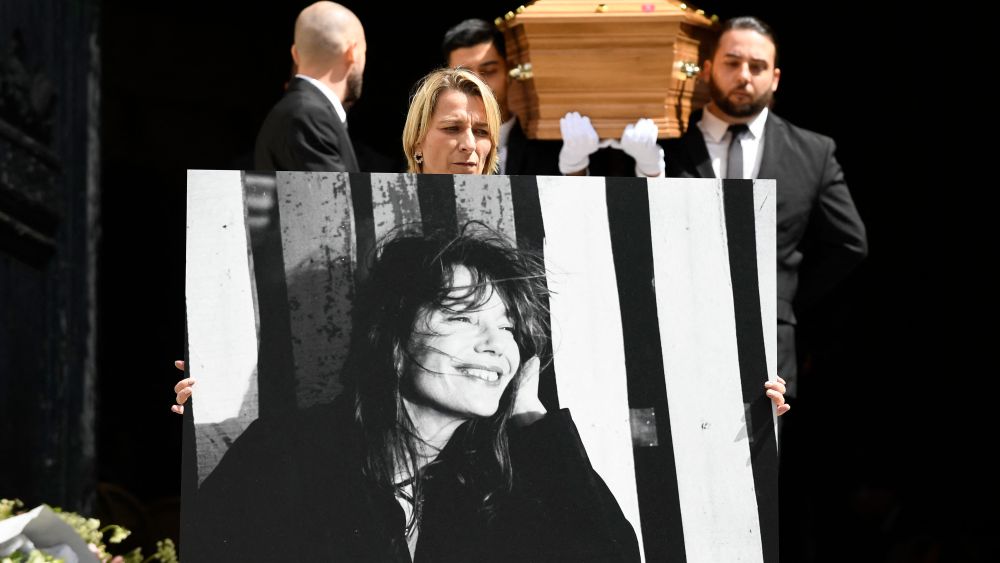 A portrait of late British-French singer and actress Jane Birkin is displayed next to her coffin at the end of the funeral ceremony in the Saint-Roch church in Paris on July 24, 2023. British-French singer and actress Jane Birkin died at 76, it was announced on July 16, 2023. (Photo by JULIEN DE ROSA / AFP) (Photo by JULIEN DE ROSA/AFP via Getty Images)