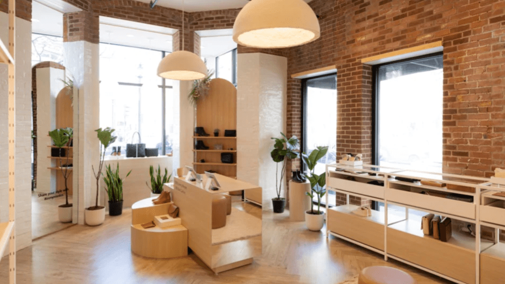 Nisolo's Boston store has warm lighting, brick and minimal wood display for its responsible shoes and accessories.