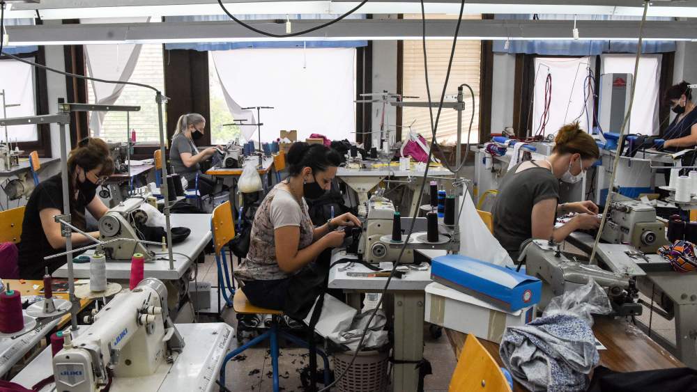 Female workers sew garments in a textile factory.