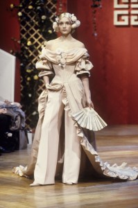 Off-the-shoulder mauve dress with ruffled trim, train and draped neckline worn over matching wide-leg trousers in the Givenchy 1999 spring couture show in Paris designed by Alexander McQueen.