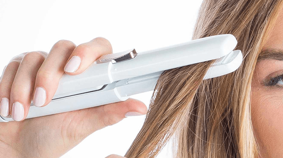 Woman using a mini flat iron to straighten her hair