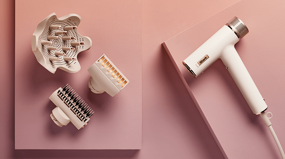 hair dryer and attachments on a pink background
