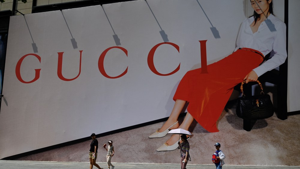People walk past a Gucci store in Beijing on August 15, 2023.
