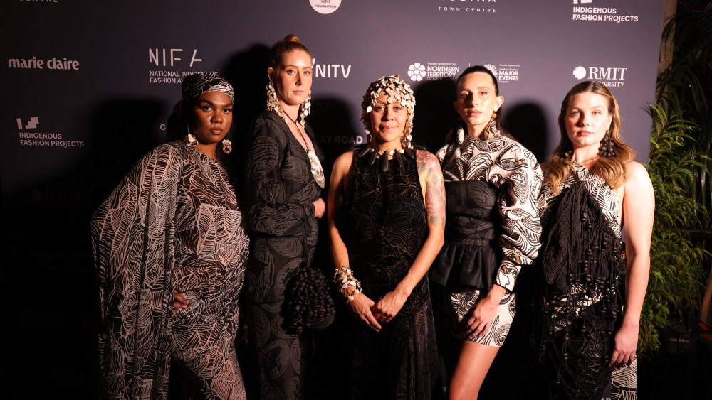 Lillardia Briggs-Houston (centre), winner of the Fashion Designer Award at the 2023 National Indigenous Fashion Awards, flanked by models wearing her designs.