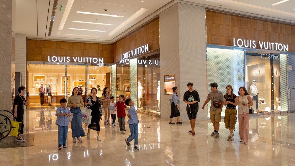 Shoppers walk pass a Louis Vuitton store in Zhengzhou, China.