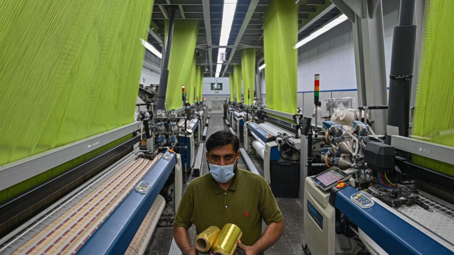 In this picture taken on July 20, 2023, a worker carries thread rolls at the Kohinoor Textile Mills in Lahore. Kohinoor is among the suppliers included on the Pakistan Accord's inaugural list of covered factories.