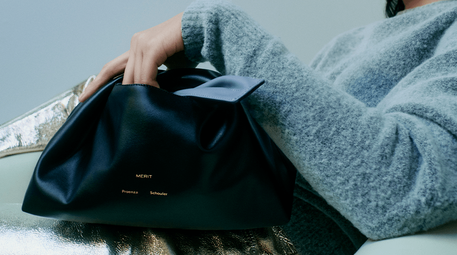 woman holding black leather makeup bag