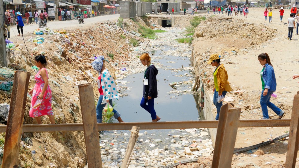 A plank straddle a shrinking river from drought in a key apparel-producing region.