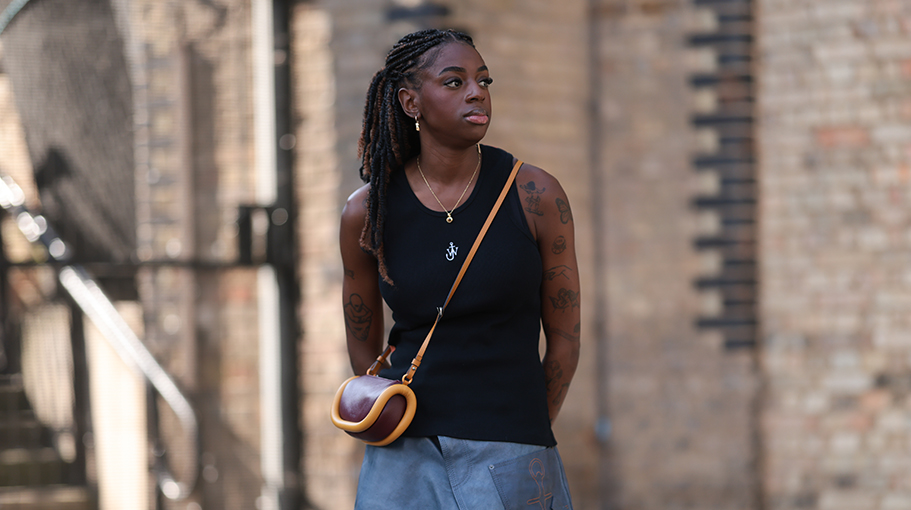 Fashion Show guest was seen wearing black JW anderson top, JW Anderson earrings in yellow gold, a yellow gold chain, blue denim shorts and black leather shoes with silver ornaments and a brown and orange JW Anderson bagbefore JW Anderson Fashion Show during London Fashion Week September 2023 at the on September 16, 2023 in London, England.