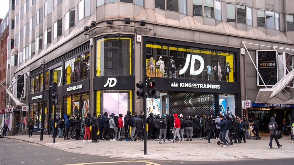 A large group of shoppers wait outside the JD Sports store on London's Oxford Street on April 12, 2021.