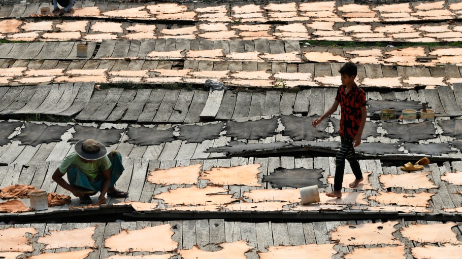 Workers set up leather pieces on a rack to make them dry at a tannery in Hazaribag, Dhaka, Bangladesh on Tuesday, March 28, 2023.