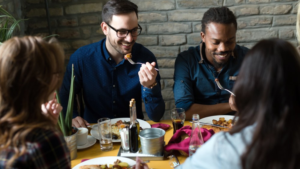 Group of happy business people eating together in restaurant