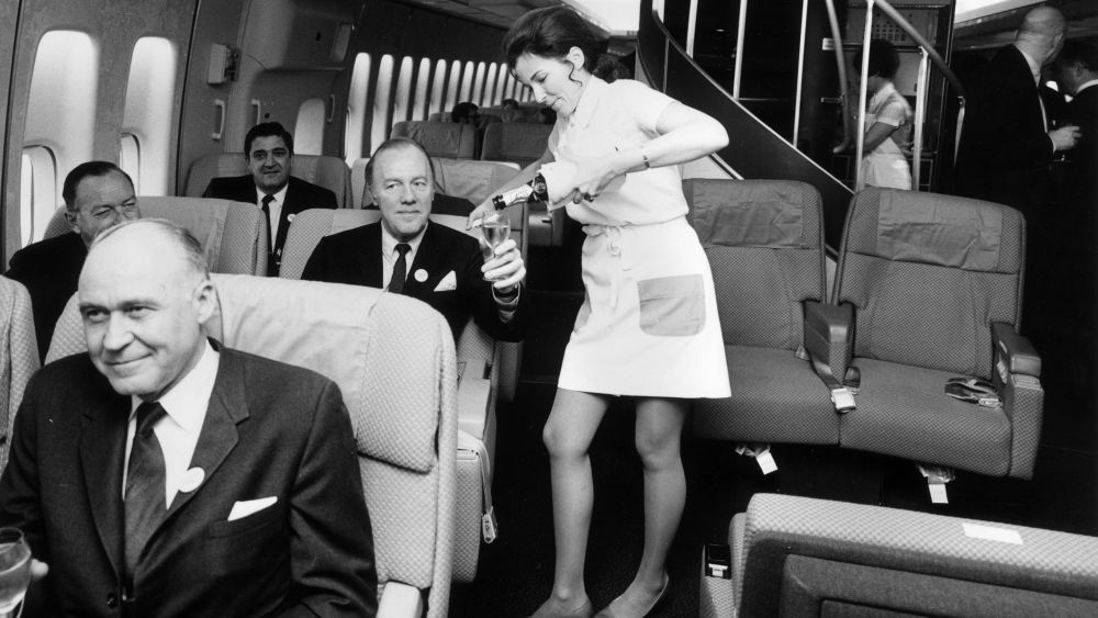 A Pan American (Pan Am) airhostess serving champagne in the first class cabin of a Boeing 747 jumbo jet.   (Photo by Tim Graham/Getty Images)