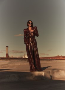 Balenciaga snake-effect leather trenchcoat, boots and sunglasses; Cartier Ecrou de Cartier ring, Clash de Cartier ring in 18-karat rose gold and Clash de Cartier bracelet in 18-karat white gold.