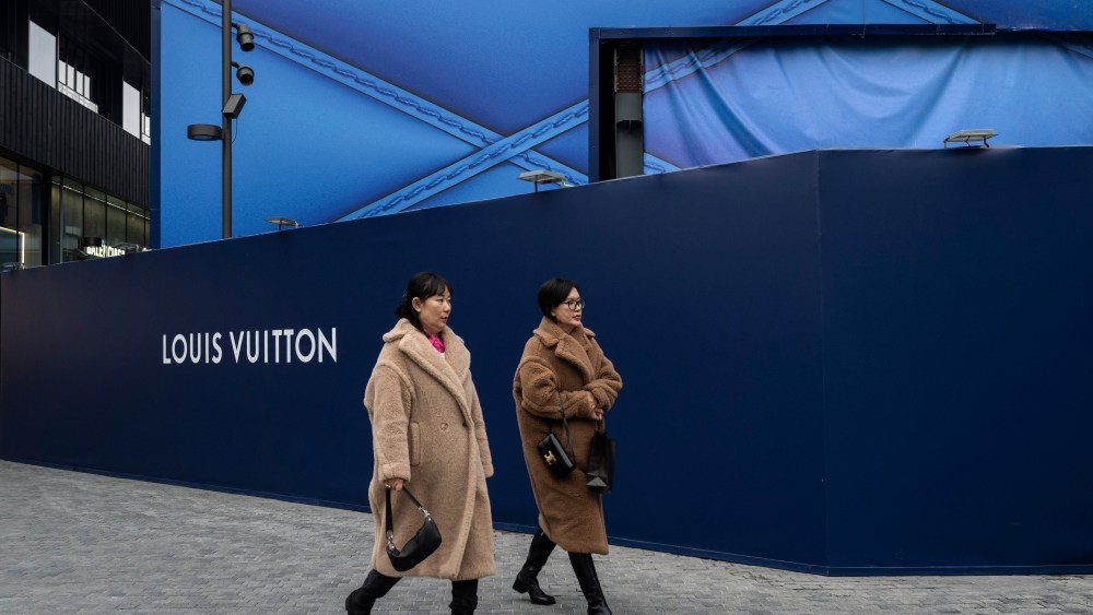 Shppers walk by a new retail shop for the luxury brand Louis Vuitton that is under construction at the Taikoo Li Sanlitun shopping complex in Beijing, China.