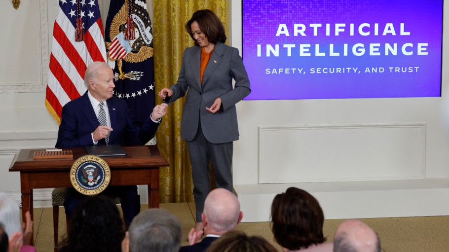 WASHINGTON, DC - OCTOBER 30: U.S. President Joe Biden hands Vice President Kamala Harris the pen he used to sign a new executive order regarding artificial intelligence during an event in the East Room of the White House on October 30, 2023 in Washington, DC. President Biden issued the executive order directing his administration to create a new chief AI officer, track companies developing the most powerful AI systems, adopt stronger privacy policies and "both deploy AI and guard against its possible bias," creating new safety guidelines and industry standards.
