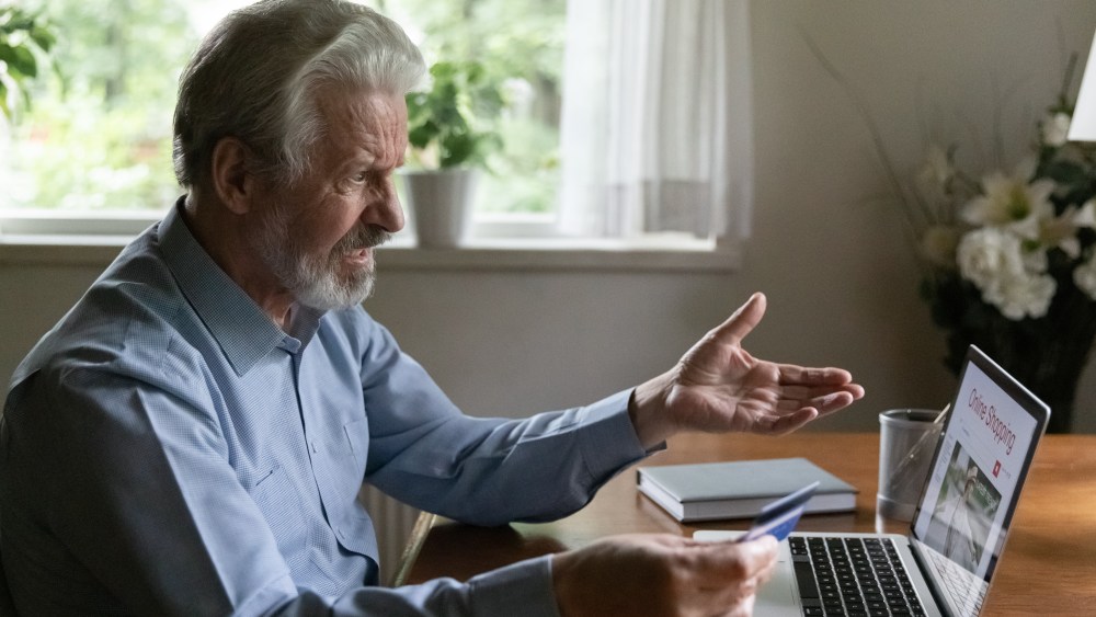 Fraud victim. Confused mature aged male online shopper look on computer screen overspending money unable to provide payment. Shocked middle aged man paid money to scammers get his credit card blocked