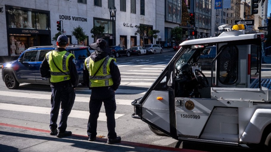 Police monitor as shoppers walk past stores in Union Square in San Francisco.
