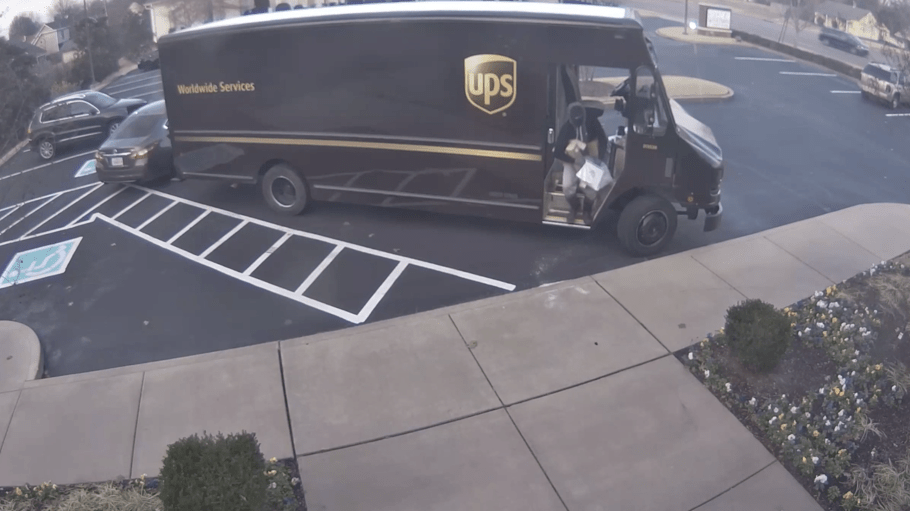 Video footage of a suspect leaving a UPS truck with several packages. The suspect is one of three shown stealing from the vehicle.