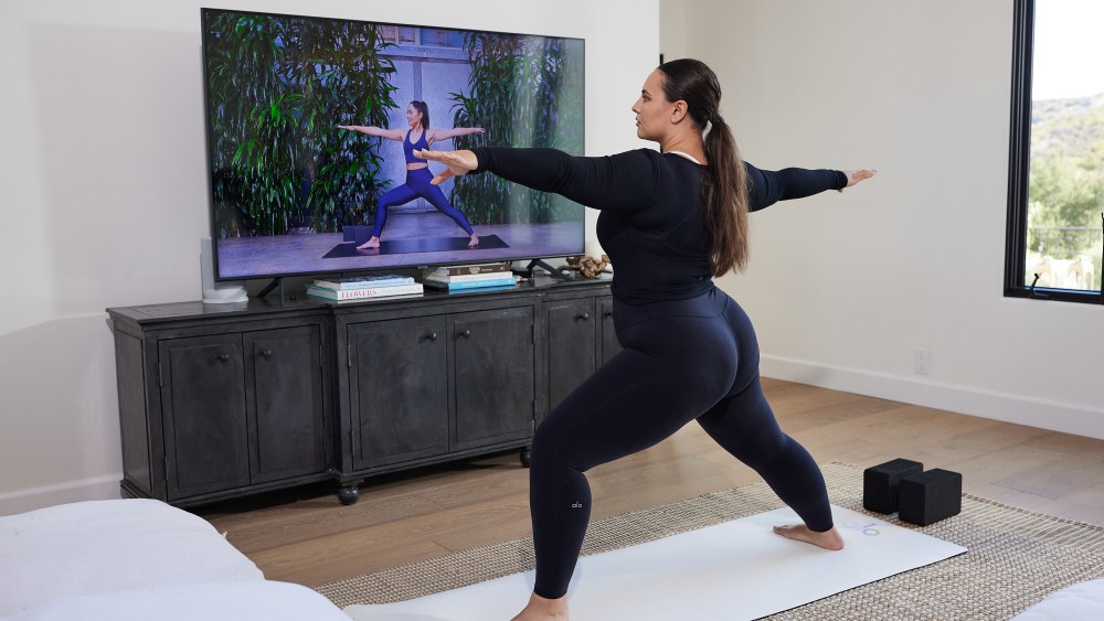 Woman working out to an Alo Moves virtual class.