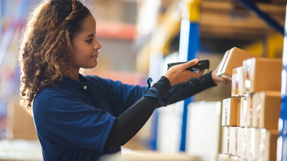 African American woman are work with business distribution inventory in warehouse factory, female people working in safety occupation job for shipping industry manufacturing