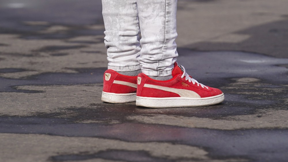 Puma red sneakers are seen, outside Chanel, during Paris Fashion Week.