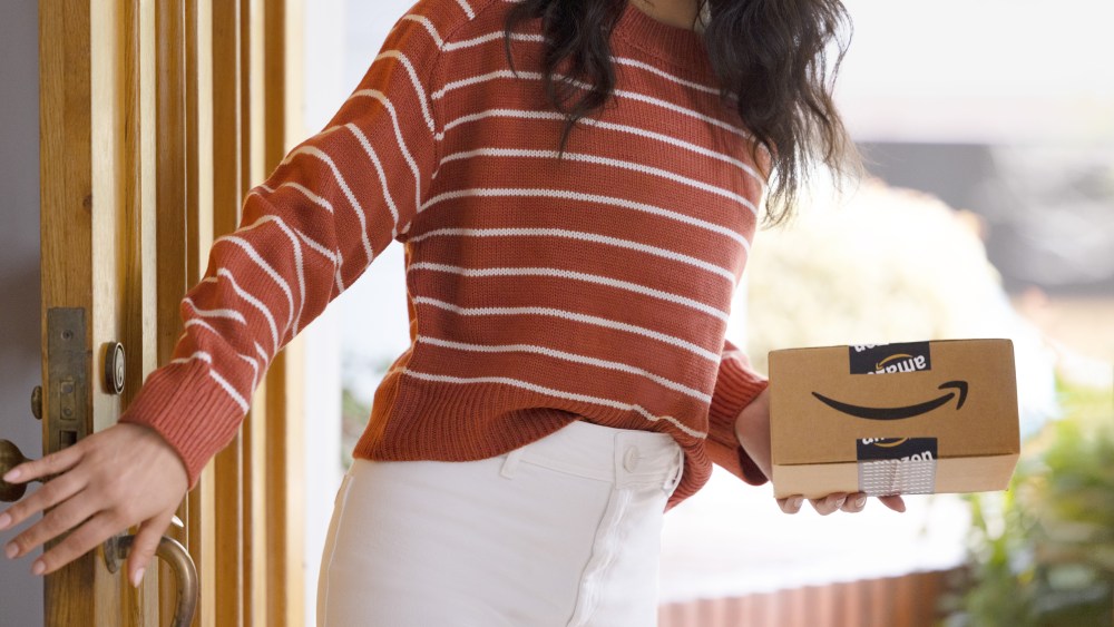 Woman in striped sweater with Amazon box.