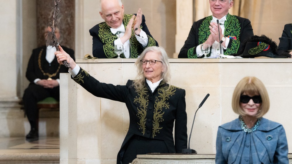 Annie Leibovitz brandishes her ceremonial sword at the Académie des Beaux-Arts as Anna Wintour leaves the podium.